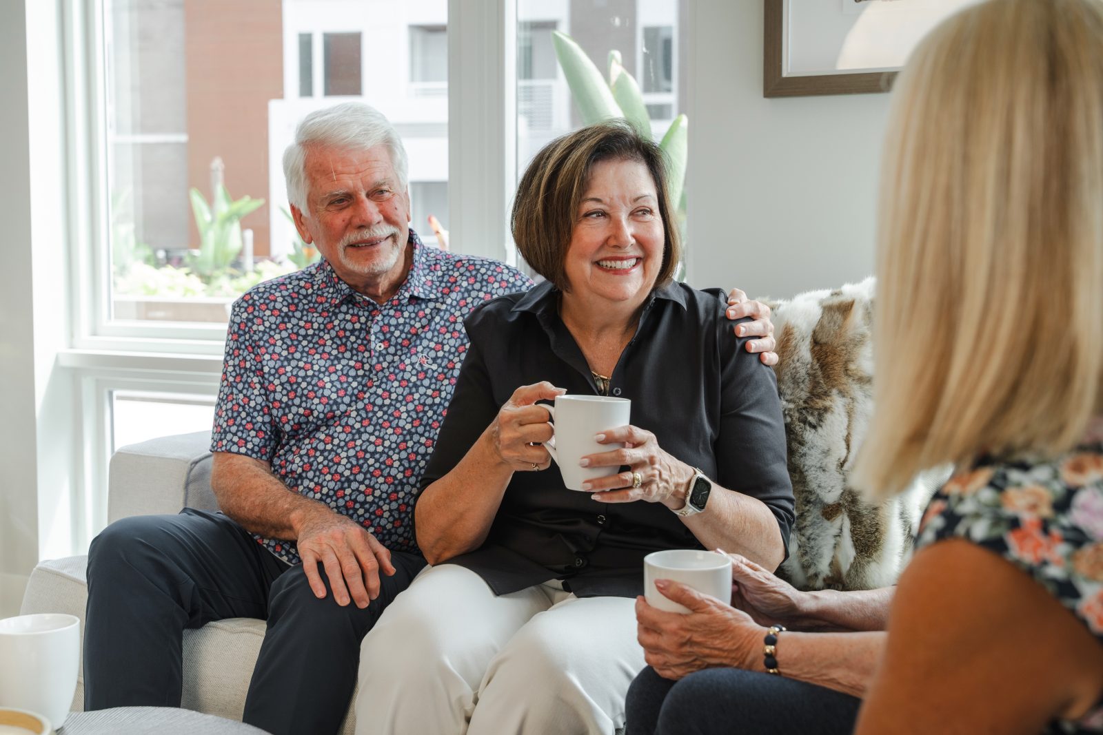 A 55+ couple relaxes in their apartment inside The Bailey at Bridge Park.